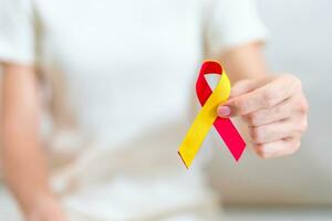 femme en portant rouge et Jaune ruban. monde hépatite journée conscience mois, 28 juillet, foie cancer, jaunisse, cirrhose, échec, agrandi, hépatique encéphalopathie et santé concept photo