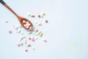 vue de dessus de nombreuses pilules et capsules colorées sur cuillère sur table photo