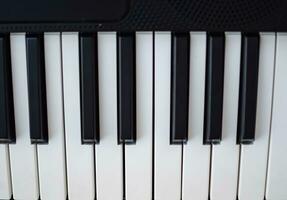 fermer de piano clés. piano noir et blanc clés et piano clavier musical instrument mis à le Accueil balcon pendant ensoleillé journée. photo