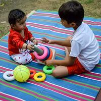 deux content garçons dans société parc, content asiatique frères qui sont souriant Heureusement ensemble. frères jouer en plein air dans été, meilleur amis. bambin bébé garçon en jouant avec le sien content frère dans le jardin photo