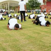 Nouveau Delhi, Inde, juin 21, 2023 - groupe yoga exercice session pour gens à yamuna des sports complexe dans delhi sur international yoga jour, gros groupe de adultes assister yoga classe dans criquet stade photo