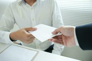 les hommes d'affaires reçoivent un salaire ou des primes de la direction ou du patron. l'entreprise donne des récompenses pour encourager le travail. homme d'affaires souriant bénéficiant d'une récompense au bureau du bureau. photo