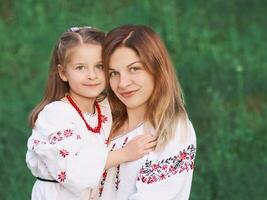 caucasien adorable peu fille câlins sa mère. ukrainien nationale vêtements, broderie, traditions photo