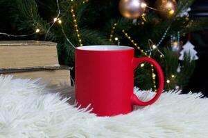 Vide rouge agresser avec Noël arbre sur fond, tapis thé ou café tasse avec Noël et Nouveau année décoration, horizontale moquer en haut avec céramique agresser pour chaud boissons, vide cadeau impression modèle photo