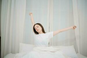 image de magnifique femme repos dans blanc lit à chambre à coucher. dans Matin . mode de vie à Accueil concept. photo