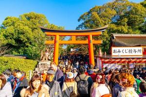 kyoto, japon - 11 janvier 2020 - portes torii rouges à fushimi inari taisha avec des touristes et des étudiants japonais. fushimi inari est le sanctuaire shinto le plus important.