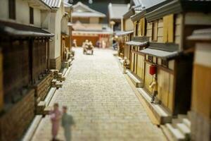 Osaka, Japon, 2018 - fermer petit route et Japonais maison dans miniature des modèles avec gens dans du quotidien la vie de Années 1800 ancien village. spectacle dans le Osaka musée de histoire. Osaka, Japon. photo