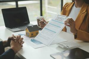 l'agent de courtage immobilier livre un échantillon d'une maison modèle au client, un contrat de prêt hypothécaire fait un bail et achète et vend une maison et contracte un concept de prêt hypothécaire d'assurance habitation photo