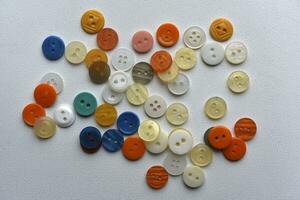 multicolore boutons sur une blanc Contexte. rond boutons de vêtements. photo