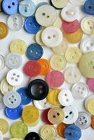 multicolore boutons sur une blanc Contexte. rond boutons de vêtements. photo