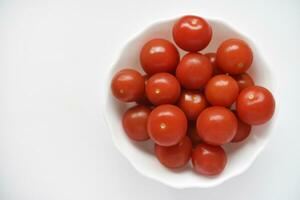 rouge des fruits de petit tomates dans une verre plaque. juteux Cerise tomates. photo