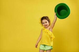 mignonne peu fille soulève sa main en portant une vert lutin irlandais chapeau dans il. Saint patrick's journée concept photo