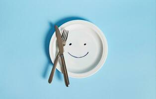 coutellerie sur un vide assiette peint avec une smiley visage photo