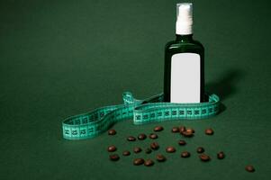 encore vie. cosmétique bouteille de foncé verre avec massage huile, mesure ruban et café des haricots épars sur vert toile de fond photo