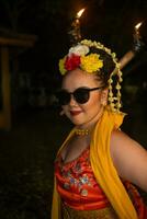 une portrait de un indonésien Danseur avec jasmin balançant dans sa cheveux orne sa magnifique apparence sur étape photo
