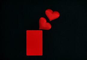 rouge cœurs, rouge verticale rectangle sur une noir Contexte. valentines journée concept. frontière, copie espace, Haut voir, fête, vacances photo