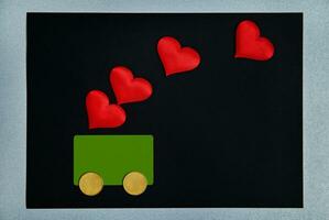 st. valentines journée concept. une vert carte avec deux argent pièces de monnaie dans le forme de roues ressemble une voiture.rouge cœurs sur Haut de eux. symbole de crédit, argent, voiture, aimer, cadeau fot valentines journée. photo