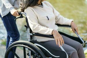 allaitement maison. Jeune soignant portion Sénior femme dans fauteuil roulant. photo