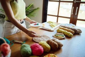 coup de poing aiguille. asiatique femme fabrication Fait main loisir tricot dans studio atelier. designer lieu de travail Fait main artisanat projet DIY broderie concept. photo