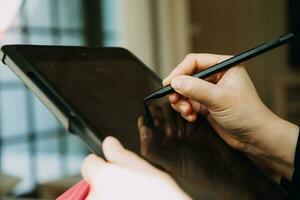 homme d'affaires mature utilisant une tablette numérique pour discuter d'informations avec un jeune collègue dans un salon d'affaires moderne photo