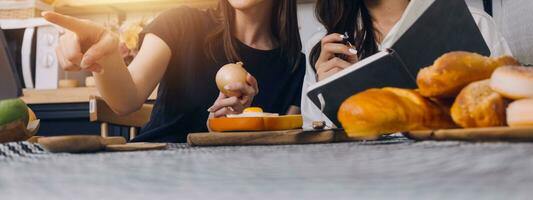 content deux Jeune femmes à la recherche portable ordinateur pendant cuisine ensemble dans cuisine pièce à maison. deux Jeune diverse lesbienne femmes dépenses temps ensemble. lgbt et le sexe identité concept photo