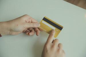 mains de femme tenant et utilisant une carte de crédit pour faire des achats en ligne. photo