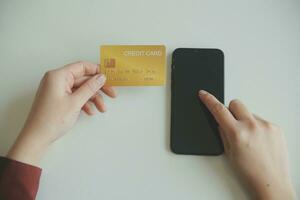 mains de femme tenant et utilisant une carte de crédit pour faire des achats en ligne. photo