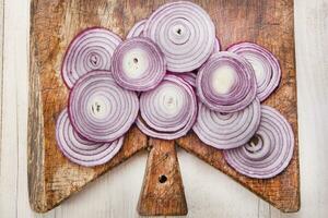 une couteau et une bouquet de oignons sur une Coupe planche photo