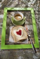 une cœur en forme de sandwich sur une assiette avec une tasse de café photo