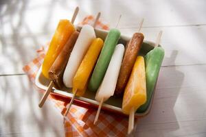 la glace pop sur une assiette avec Orange et vert rayures photo