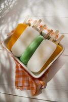 la glace pop sur une assiette avec Orange et vert rayures photo