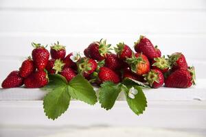 une fraise est séance sur une étagère dans de face de une blanc mur photo