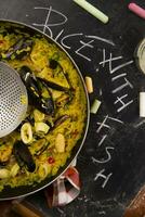 riz avec moules et des légumes sur une noir nappe de table avec tableau noir riz photo