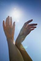 femelle mains dans le bleu ciel dans le contre-jour photo