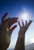 femelle mains dans le bleu ciel dans le contre-jour photo