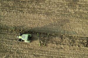 aérien vue de une tracteur à le temps de hiver sol préparation photo