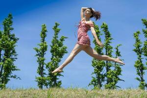 fille sauter dans la nature dans printemps saison photo