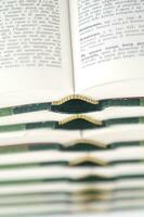 une empiler de ouvert livres avec vert et or réduire photo