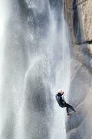 une la personne sur une corde escalade en haut une cascade photo