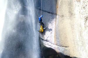 une la personne sur une corde escalade en haut une cascade photo