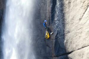 une la personne sur une corde escalade en haut une cascade photo