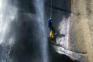 une la personne sur une corde escalade en haut une cascade photo