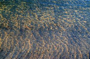 le l'eau est clair et bleu avec le sable photo