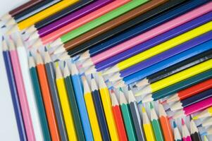 beaucoup coloré des crayons sont arrangé dans une rangée photo