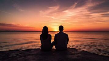 couple séance séparément en train de regarder le le coucher du soleil plus de le mer photo