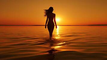 un femme en marchant sur le plage à le coucher du soleil photo