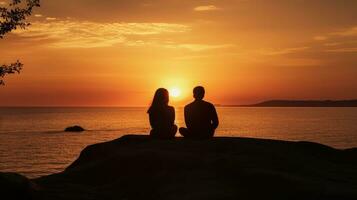 couple séance séparément en train de regarder le le coucher du soleil plus de le mer photo