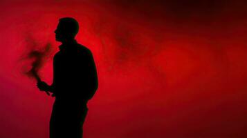 une homme avec une rouge fumée bâton capturé dans silhouette photo