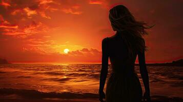 femme s silhouette en train de regarder plage le coucher du soleil photo