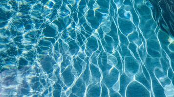 abstrait bassin l'eau. nager bassin bas caustiques ondulation et couler avec vagues Contexte surface de bleu nager bassin photo